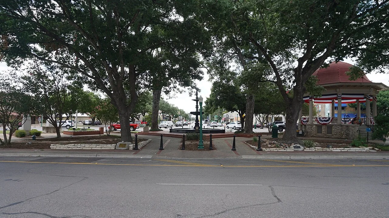 Main Plaza and its bandstand beneath mature trees in New Braunfels, photographed in 2017
