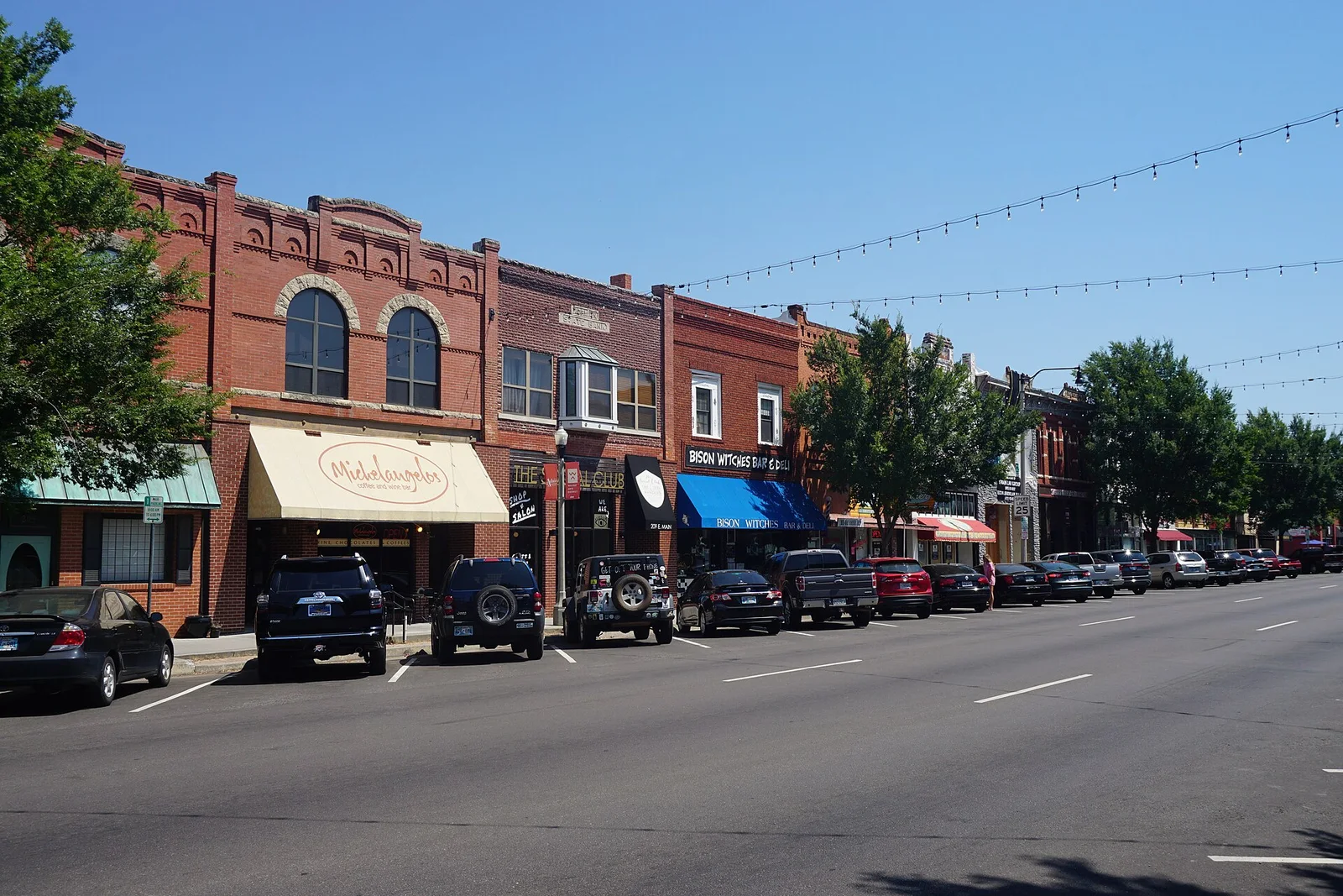 East Main Street storefronts and parked cars in downtown Norman in July 2019