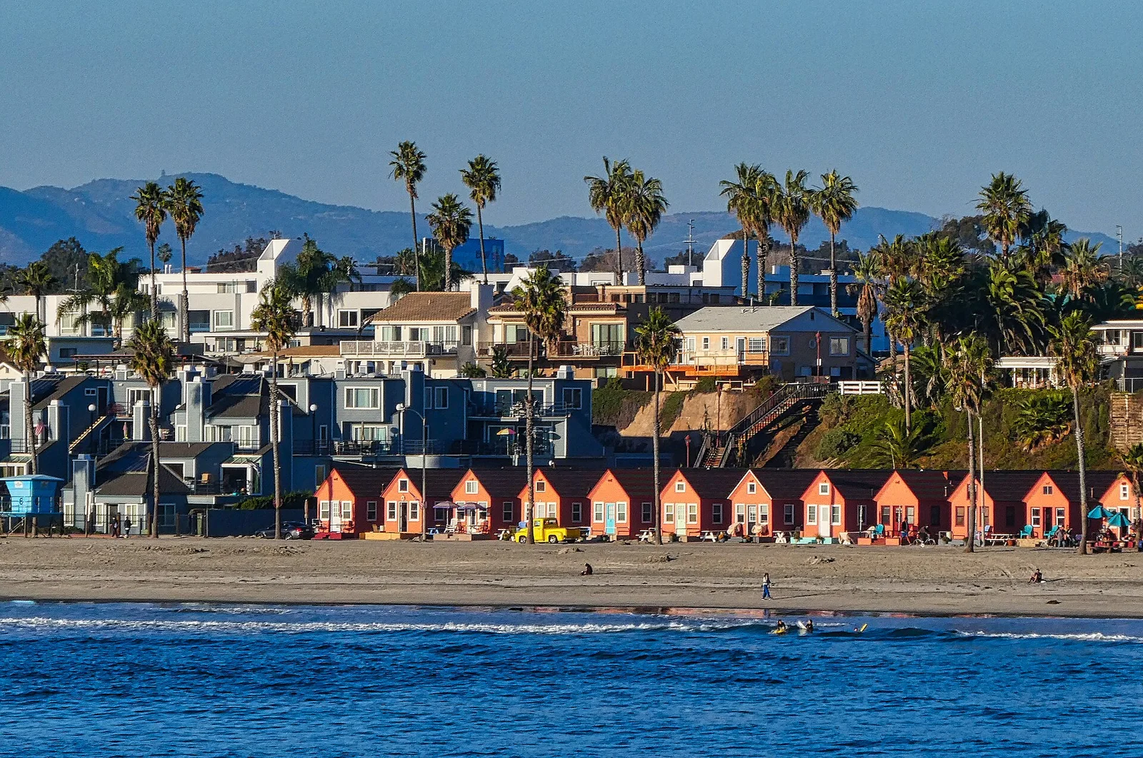 Oceanside beach, colorful beachfront cottages and palm trees viewed from the pier in 2020